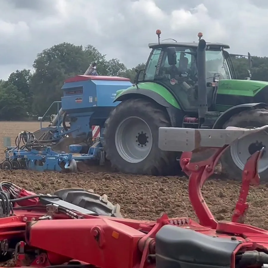 Tracteur avec combiné de semis bleu, derrière la charrue